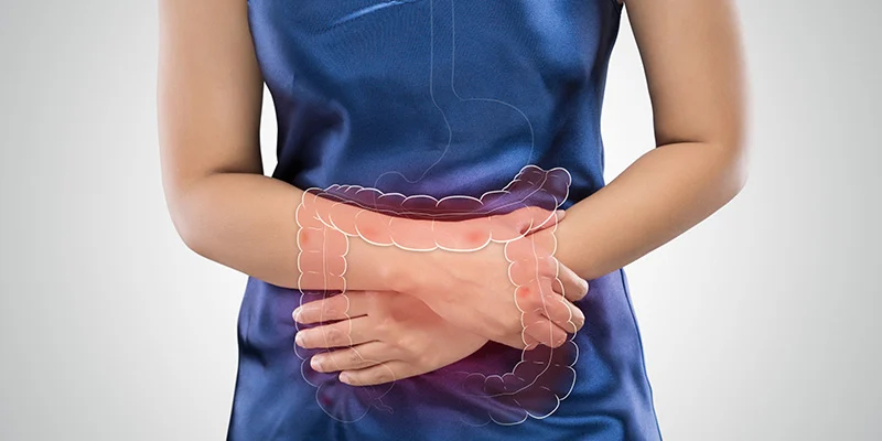 Dettaglio di un intestino disegnato sul busto di una donna che ha le mani sulla pancia