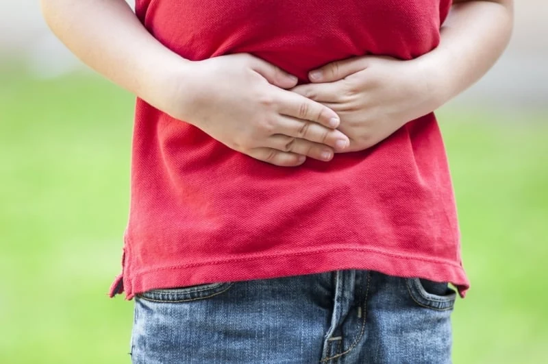 Dettaglio di un bambino con le mani sulla pancia