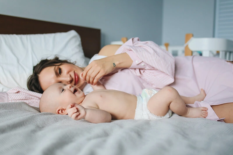 Donna e bambino distesi su un letto